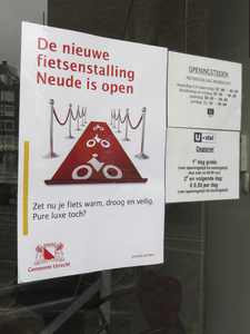 908131 Afbeelding van een affiche met de mededeling dat de nieuwe fietsenstalling Neude open is. De stalling is ...